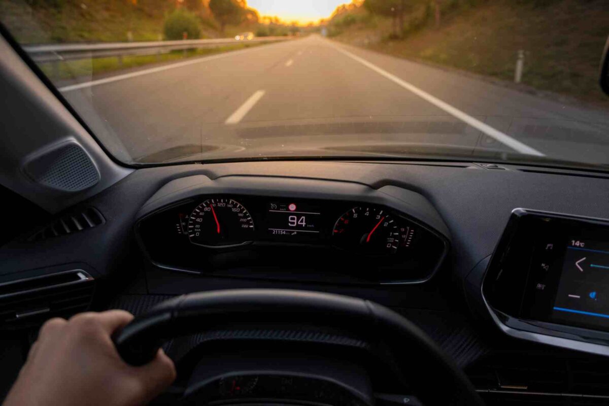hands of car driver on steering wheel, road trip, driving on highway road