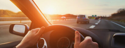 hands of car driver on steering wheel, road trip, driving on highway road