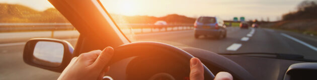 hands of car driver on steering wheel, road trip, driving on highway road