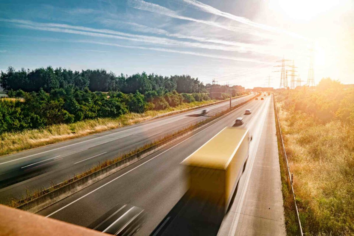 Heavy goods vehicles and cars moving along a motorway