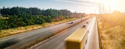 Heavy goods vehicles and cars moving along a motorway