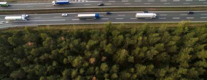 Voie rapide au milieu de la forêt partagée par les voitures et les poids lourds.